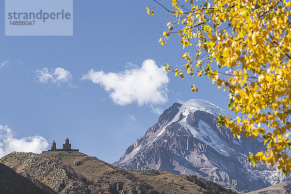 Georgien  Großkaukasus  Stepantsminda  Dreifaltigkeitskirche von Gergeti und Berg Kasbek im Herbst