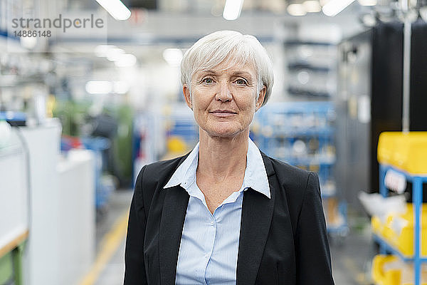 Porträt einer selbstbewussten älteren Geschäftsfrau in einer Fabrik