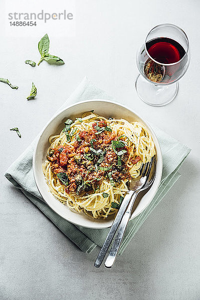 Spaghetti mit Tomaten-Kapernsauce  Basilikum und Parmesan mit einem Glas Rotwein