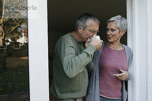 Älteres Ehepaar trinkt Kaffee an der Terrassentür
