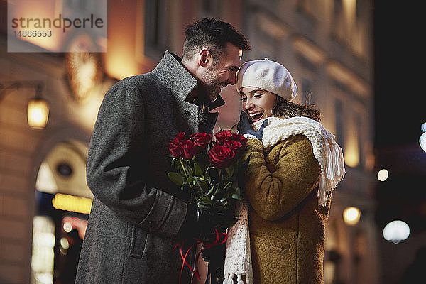 Mann schenkt seiner verblüfften Freundin am Valentinstag einen Strauß roter Rosen