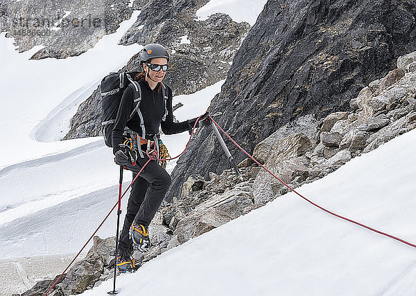 Grönland  Sermersooq  Kulusuk  Schweizer Alpen  Bergsteiger im Schnee aufsteigender Berg