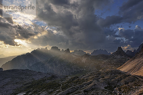 Dreizinnenhütte mit den Bergen Tobliner Knoten  Torre dei Scarperi  Croda dei Rondoi  Cima Piatta Alta und dramatischem Himmel mit Sonnenstrahlen. Parco Naturale Tre Cime  Italien