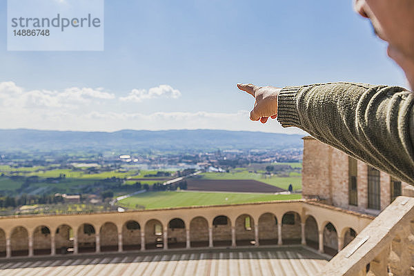 Italien  Umbrien  Assisi  Männerhand zeigt auf die Felder um die Basilika San Francesco d'Assisi