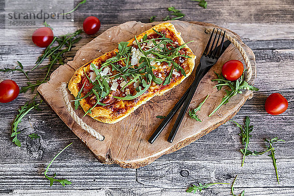 Hausgemachte Pizza mit Rucola  Parmaschinken  Tomate und Parmesan