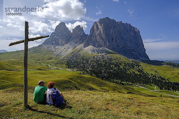 Italien  Südtirol  Sellagruppe  Wanderer am Gipfelkreuz sitzend