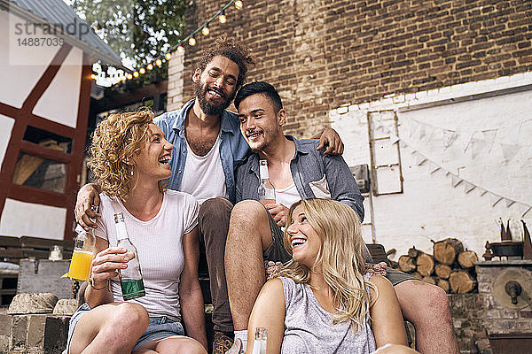 Freunde amüsieren sich im Sommer in einem Hinterhof