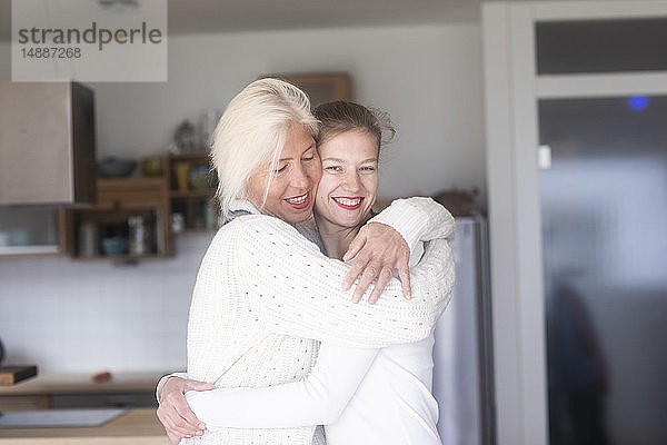 Porträt einer glücklichen Mutter  die ihre erwachsene Tochter zu Hause umarmt