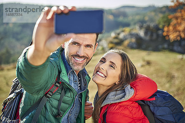 Glückliches Paar auf einer Wanderung in den Bergen mit einem Selfie