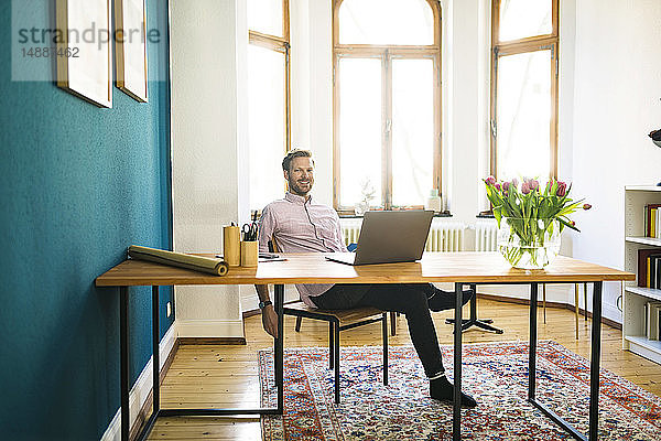 Porträt eines glücklichen entspannten Geschäftsmannes im Home Office