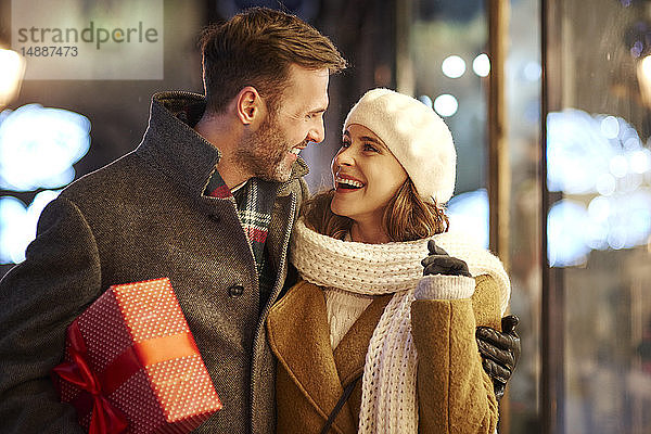 Glückliches Paar auf Einkaufstour zur Weihnachtszeit beim gegenseitigen Anschauen