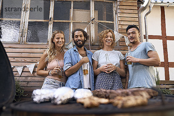 Freunde amüsieren sich auf einer Grillparty  trinken Bier