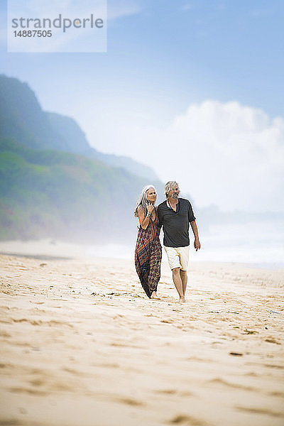 Älteres Hippie-Paar beim gemeinsamen Strandspaziergang
