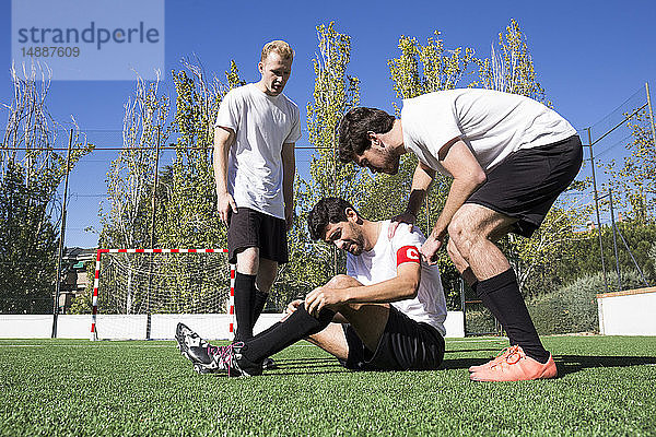 Fussballspieler helfen einem verletzten Spieler während eines Spiels
