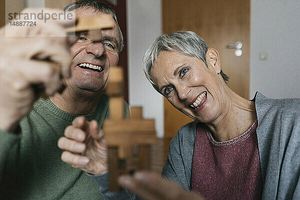 Glückliches Seniorenpaar beim Geschicklichkeitsspiel zu Hause