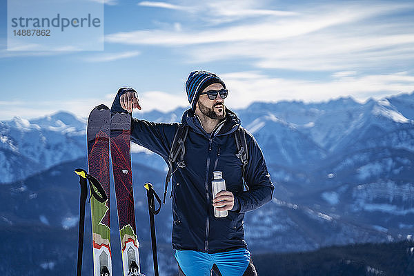 Deutschland  Bayern  Brauneck  Mann auf einer Skitour im Winter in den Bergen bei einer Pause