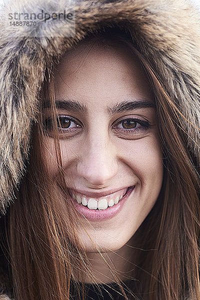 Porträt einer glücklichen jungen Frau mit Pelzkapuze