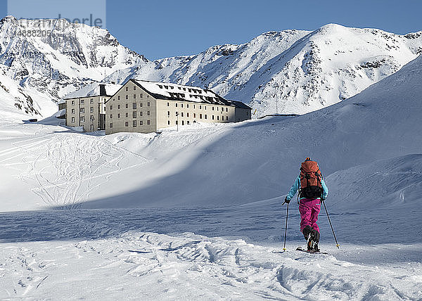 Schweiz  Hospiz Großer St. Bernhard  Frau beim Skitourengehen in den Bergen