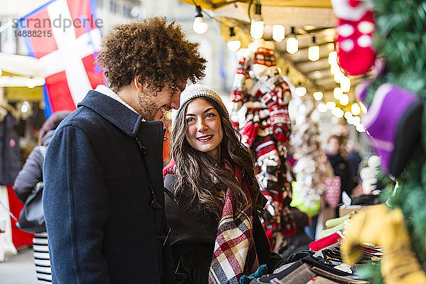 Glückliches junges Paar auf dem Weihnachtsmarkt