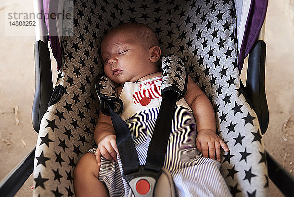 Porträt eines kleinen Jungen  der im Kindersitz schläft