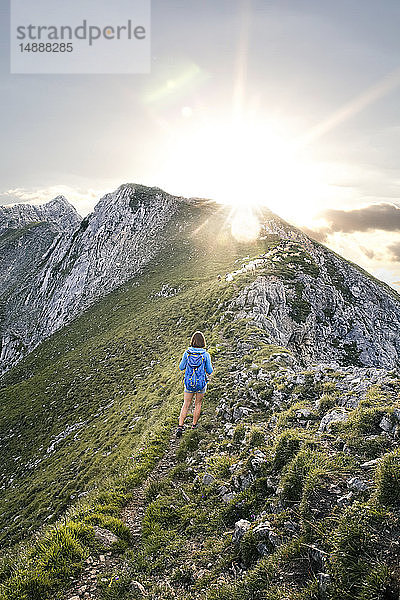 Österreich  Tirol  Frau auf einer Wanderung in den Bergen bei Sonnenuntergang