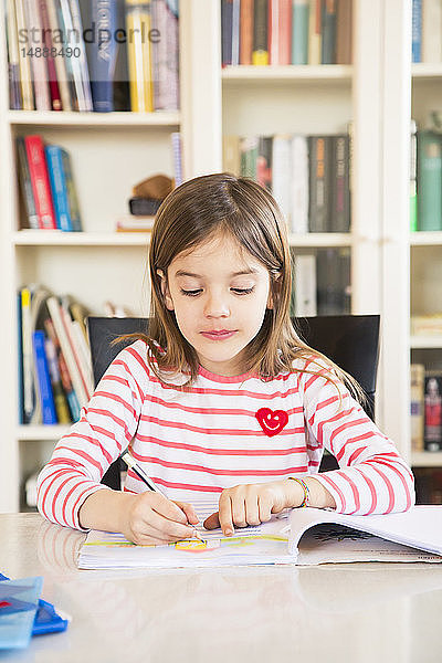 Porträt eines kleinen Mädchens bei den Hausaufgaben