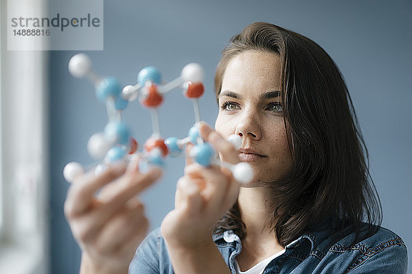 Weibliche Wissenschaftlerin untersucht Molekülmodell  sucht nach Lösungen