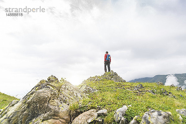 Mann  der auf einem Hügel steht und die Landschaft in den Karpaten betrachtet  Rumänien