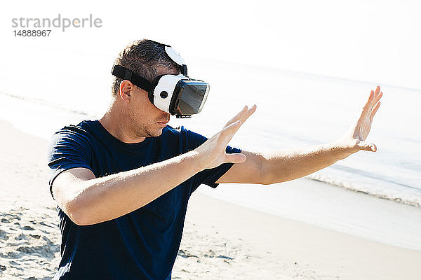 Mann mit VR-Brille am Strand