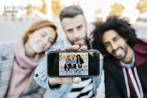 Drei Freunde zeigen ein Selfie am Kameratelefon