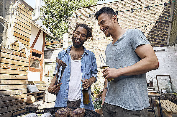 Freunde bereiten Fleisch für ein Barbecue im Hinterhof