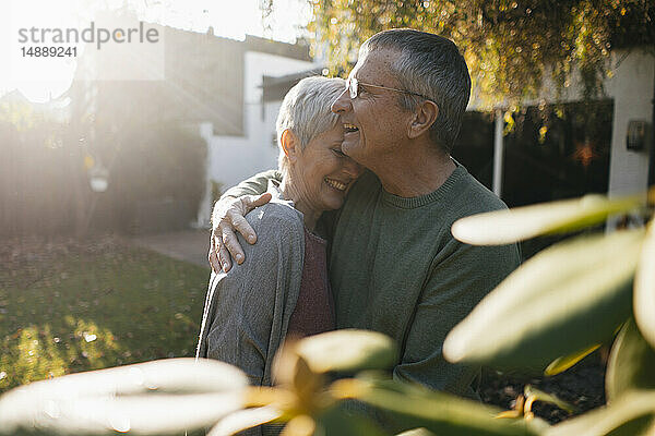 Glückliches  anhängliches Seniorenpaar umarmt sich im Garten