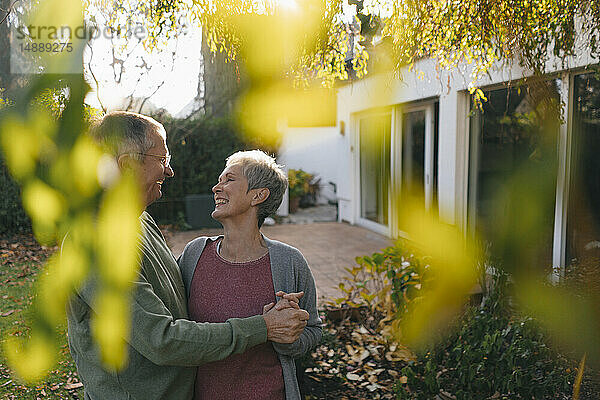 Glückliches  anhängliches Seniorenpaar im Garten