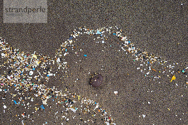 Spanien  Kanarische Inseln  Lanzarote  Playa Famara  Mikroplastik  angespült auf dunklen Lavasand