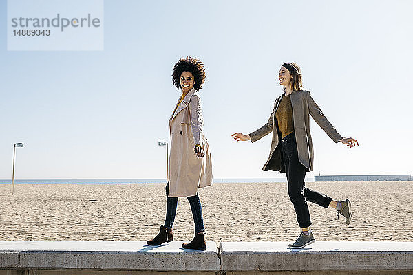 Zwei glückliche Freunde spazieren auf der Promenade und genießen ihre Freizeit