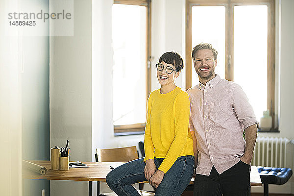 Porträt eines glücklichen Paares bei Tisch in stilvoller Wohnung