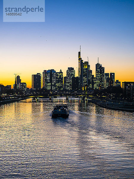 Deutschland  Hessen  Frankfurt  Skyline des Finanzdistrikts  Main und Deutschherrn-Brücke  Frachtschiff bei Sonnenuntergang