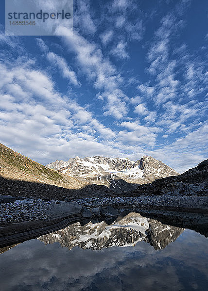Grönland  Sermersooq  Kulusuk  Schweizer Alpen  Mann steht am See mit Bergen  die sich im Wasser spiegeln