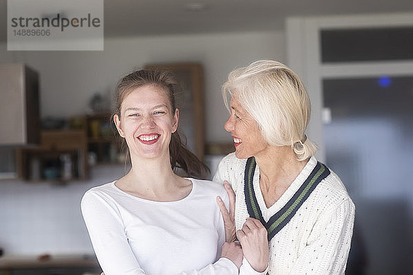 Porträt einer lachenden jungen Frau und ihrer Mutter zu Hause