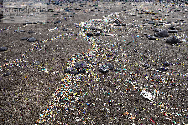 Spanien  Kanarische Inseln  Lanzarote  Playa Famara  Mikroplastik  angespült auf dunklen Lavasand
