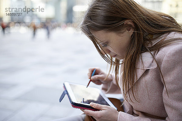 Österreich  Wien  junge Frau mit digitalem Tablet in der Stadt