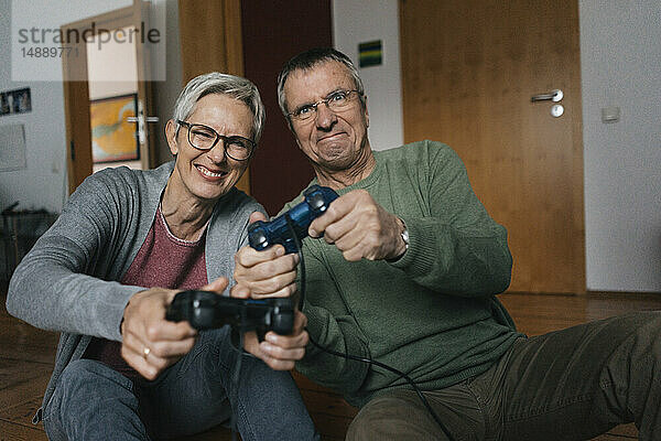 Glückliches älteres Ehepaar spielt zu Hause Videospiel