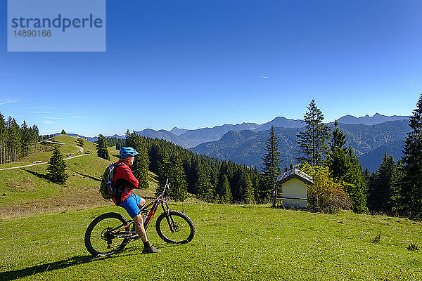 Deutschland  Mountainbiker mit Blick auf Hirschtalsattel  Aueralm mit Tegernseer Bergen bei Lenggries