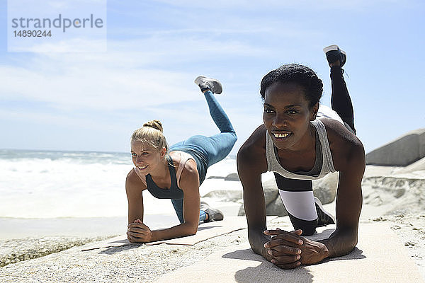 Zwei Frauen bei einer Fitnessübung am Strand