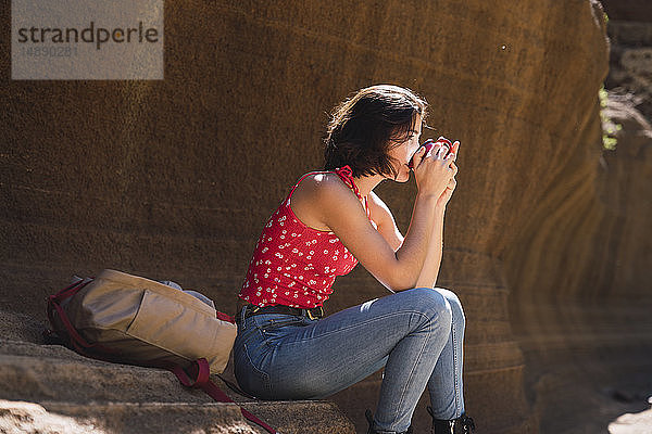 Spanien  Gran Canaria  Barranco de las Vacas  junge Frau ruht sich mit Trinkwasser aus