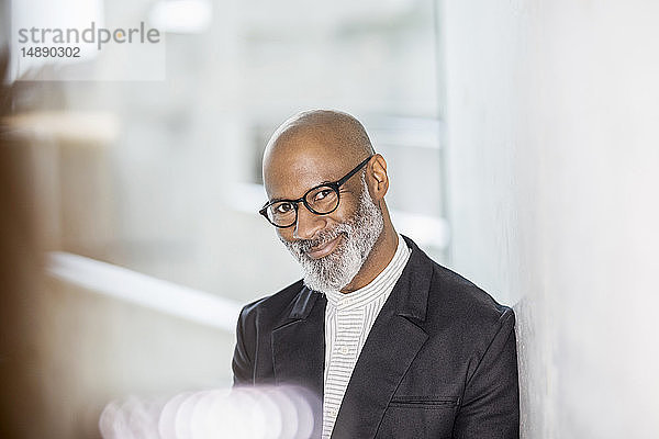 Porträt eines kahlköpfigen reifen Geschäftsmannes mit grauem Bart und Brille