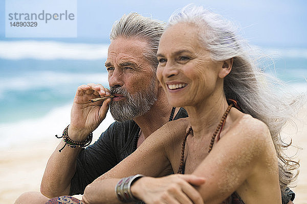 Älteres Hippie-Paar entspannt gemeinsam am Strand