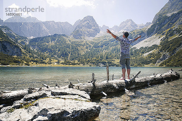Österreich  Tirol  Mann auf Baumstamm am Seebensee stehend