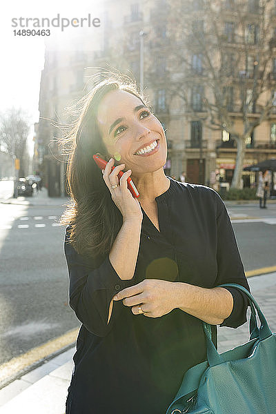 Elegante Frau telefoniert in der Stadt mit dem Handy