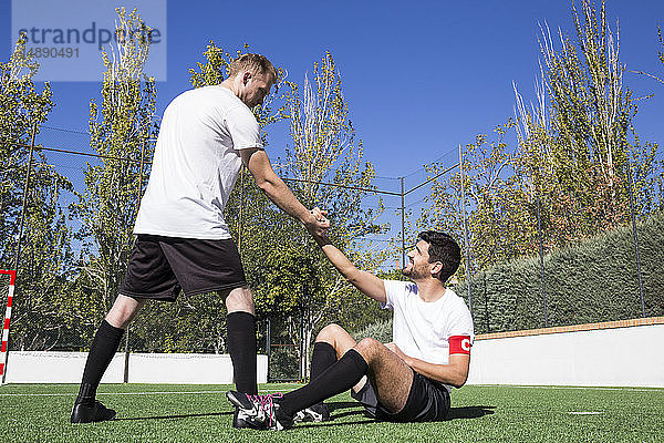 Fussballspieler hilft einem verletzten Spieler während eines Spiels